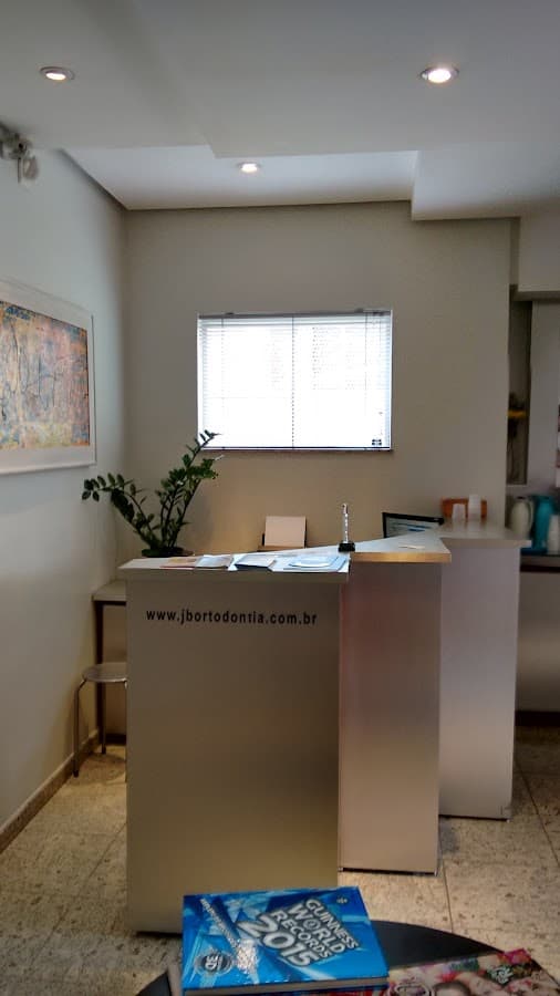 Recepção da clínica odontológica com boa iluminação e organização.